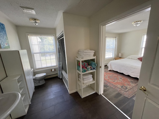 20 Chase Brook Dr, Alexander, ME 04694 - full bath with toilet, baseboard heating, a textured ceiling,  shower combination, and tile patterned floors