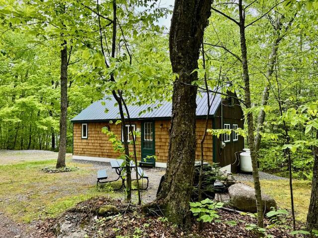 57 Cranberry Dr, Embden, ME 04958 - view of front of property with metal roof and a forest view