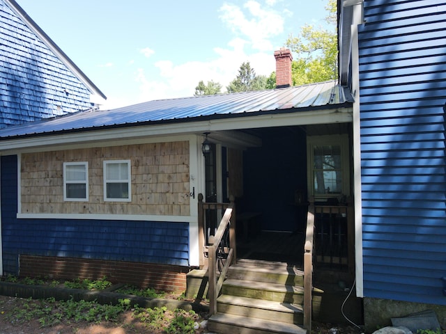 37 Enfield Rd, Lincoln, ME 04457 - view of exterior entry with metal roof and a chimney
