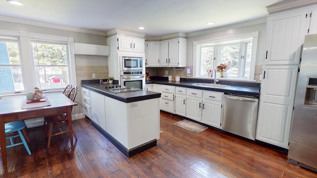37 Enfield Rd, Lincoln, ME 04457 - kitchen featuring stainless steel appliances, a sink, dark countertops, crown molding, and a peninsula