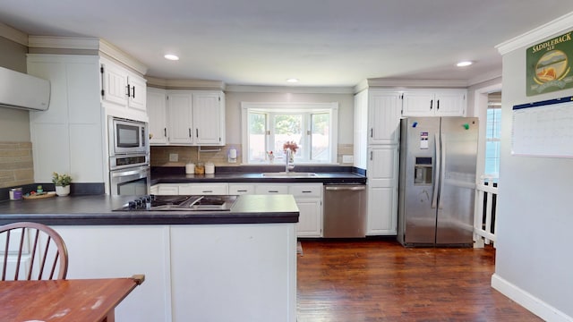 37 Enfield Rd, Lincoln, ME 04457 - kitchen with stainless steel appliances, a sink, dark countertops, a peninsula, and backsplash
