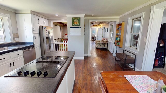 37 Enfield Rd, Lincoln, ME 04457 - kitchen with stainless steel appliances, dark countertops, white cabinets, crown molding, and dark wood-style flooring