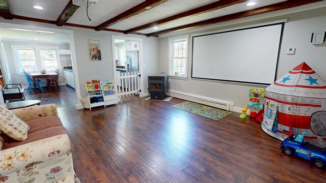 37 Enfield Rd, Lincoln, ME 04457 - home theater with baseboard heating, a wood stove, beam ceiling, wood finished floors, and recessed lighting
