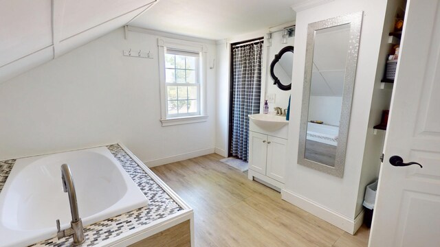 37 Enfield Rd, Lincoln, ME 04457 - full bathroom featuring wood finished floors, vanity, a bath, and baseboards