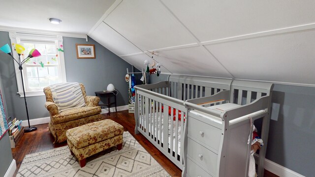37 Enfield Rd, Lincoln, ME 04457 - bedroom featuring wood finished floors, baseboards, lofted ceiling, and a crib