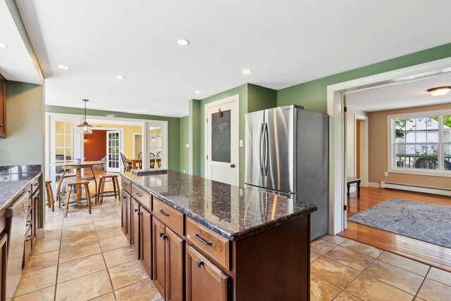 17 S Rd, Winthrop, ME 04364 - kitchen featuring stainless steel appliances, baseboard heating, a center island, dark stone countertops, and hanging light fixtures