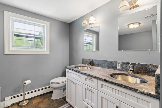 17 S Rd, Winthrop, ME 04364 - bathroom with a baseboard heating unit, toilet, double vanity, and baseboards