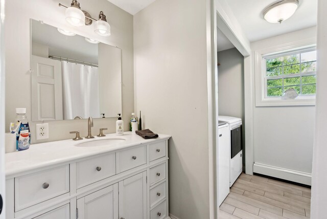 17 S Rd, Winthrop, ME 04364 - bathroom with washer and dryer, a baseboard radiator, vanity, wood finished floors, and baseboards