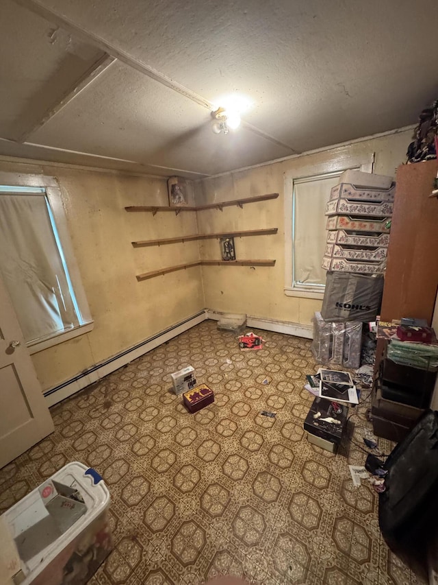 below grade area featuring a baseboard heating unit and a textured ceiling
