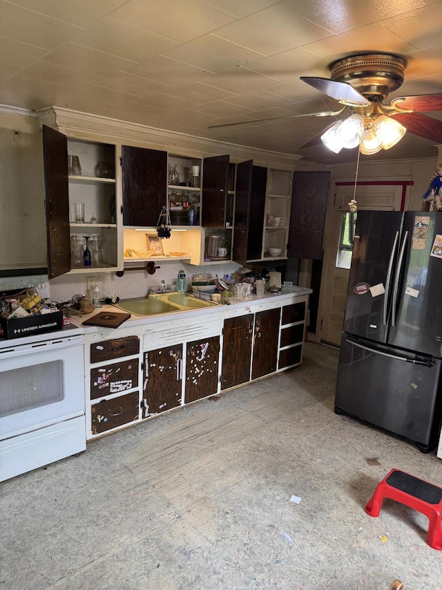 kitchen featuring freestanding refrigerator, white electric range oven, open shelves, a sink, and dark brown cabinetry