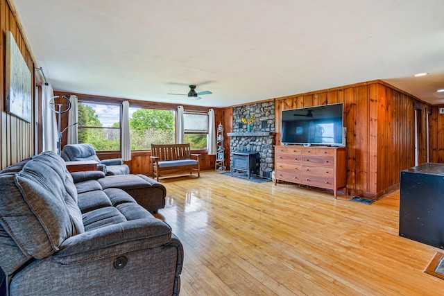 206 Sebago Lake Rd, Gorham, ME 04038 - living room with a wood stove, ceiling fan, light wood-style floors, and wooden walls