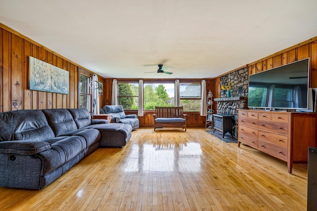 206 Sebago Lake Rd, Gorham, ME 04038 - living area with a ceiling fan, a wood stove, light wood-type flooring, and wooden walls