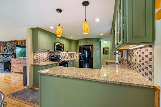 206 Sebago Lake Rd, Gorham, ME 04038 - kitchen featuring black appliances, a sink, decorative backsplash, light wood-style floors, and a peninsula