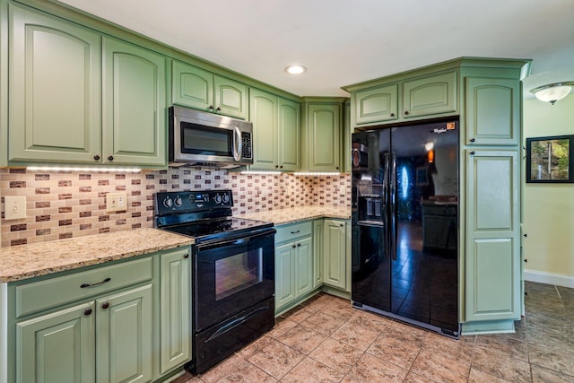 206 Sebago Lake Rd, Gorham, ME 04038 - kitchen with black appliances, backsplash, light stone counters, light tile patterned floors, and baseboards