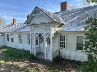 15 River Rd, Phillips, ME 04966 - rear view of property featuring a chimney, a standing seam roof, and metal roof