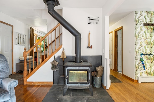 35 Salem Towne Rd, Southwest Harbor, ME 04679 - detailed view of a wood stove, wood finished floors, a baseboard heating unit, and baseboards