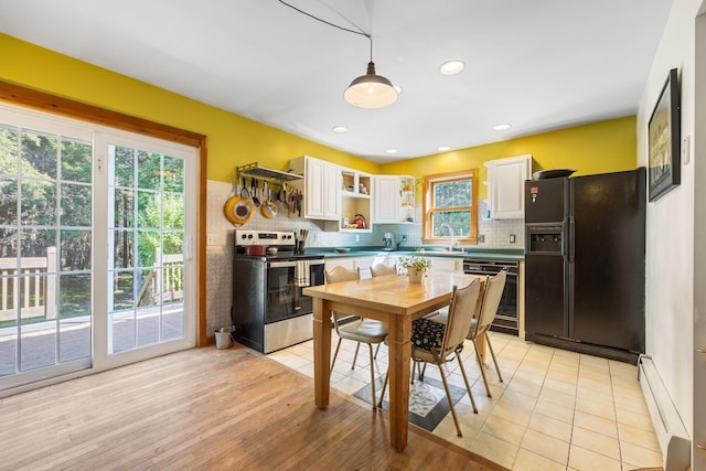 35 Salem Towne Rd, Southwest Harbor, ME 04679 - kitchen with stainless steel range with electric stovetop, black refrigerator with ice dispenser, a baseboard radiator, dishwashing machine, and white cabinets