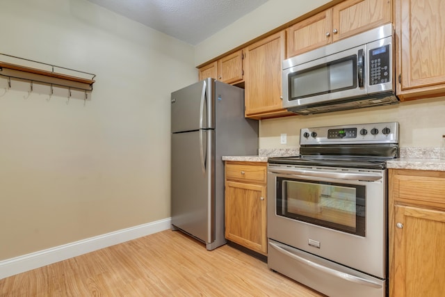 18 Smithwheel Rd Unit 21, Old Orchard Beach, ME 04064 - kitchen with appliances with stainless steel finishes, light wood-style floors, and baseboards