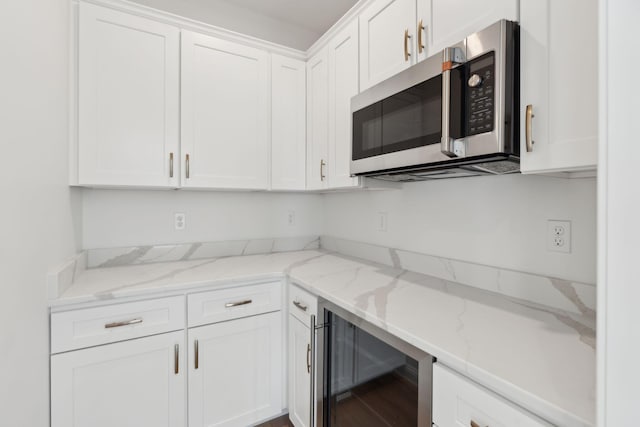 90 Running Hill Rd, Scarborough, ME 04074 - kitchen featuring stainless steel microwave, beverage cooler, white cabinetry, and light stone countertops