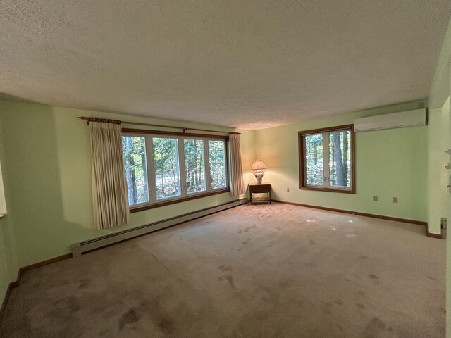 96 Pamela Dr, Winthrop, ME 04364 - carpeted spare room with a baseboard radiator, a wall unit AC, a textured ceiling, and baseboards