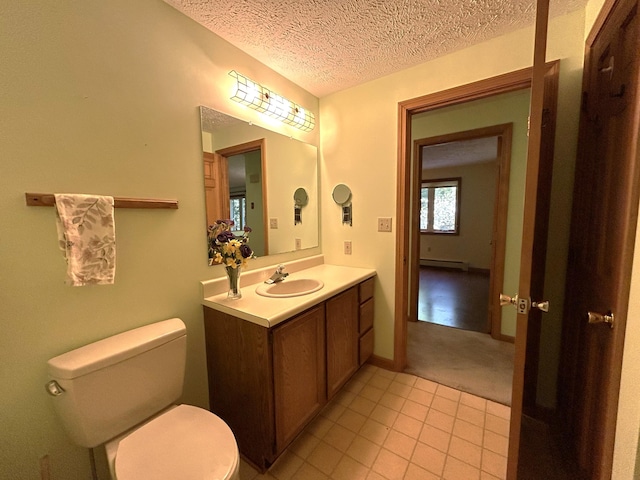 96 Pamela Dr, Winthrop, ME 04364 - bathroom with vanity, toilet, a baseboard heating unit, a textured ceiling, and tile patterned floors