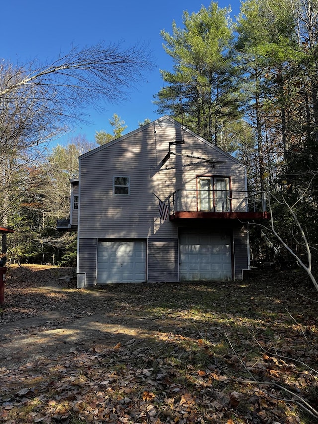 371 Carding Machine Rd, Bowdoinham, ME 04008 - view of property exterior featuring an attached garage and dirt driveway