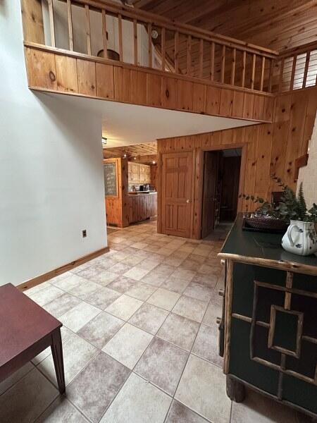 27 Chickadee Ln, Naples, ME 04055 - unfurnished living room featuring wood walls and baseboards