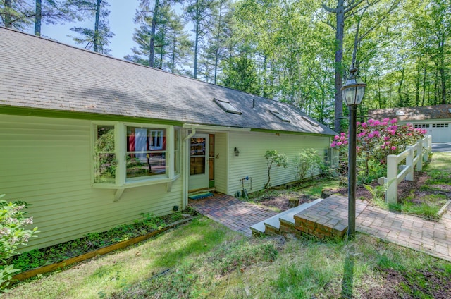 27 Chickadee Ln, Naples, ME 04055 - rear view of property with a shingled roof and a patio area