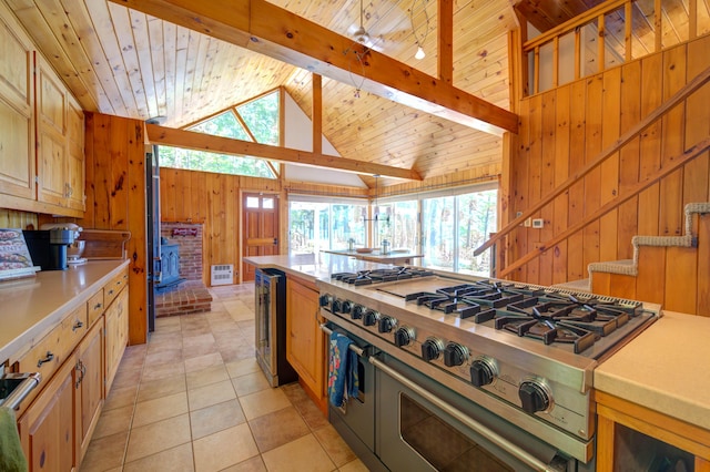 27 Chickadee Ln, Naples, ME 04055 - kitchen with double oven range, a wood stove, wooden walls, wooden ceiling, and light countertops