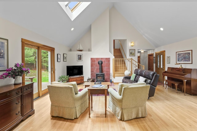68 Parker Farm Rd, Mount Desert, ME 04660 - living room with high vaulted ceiling, a wood stove, a skylight, light wood-style floors, and stairs