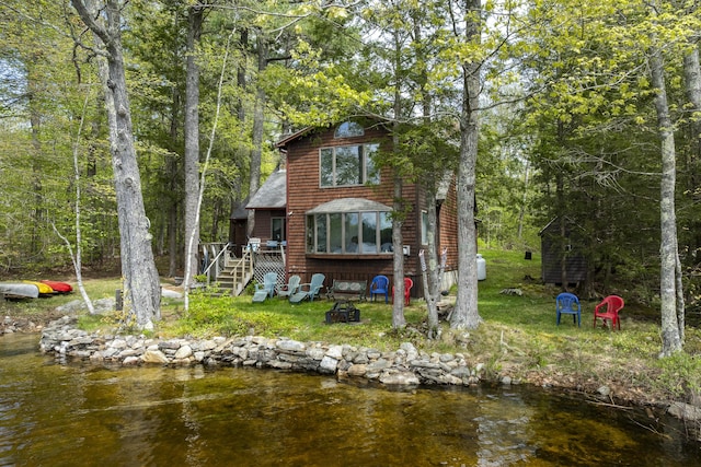 711 Biscay Rd, Bremen, ME 04551 - back of property with stairs, a fire pit, a deck with water view, and a lawn