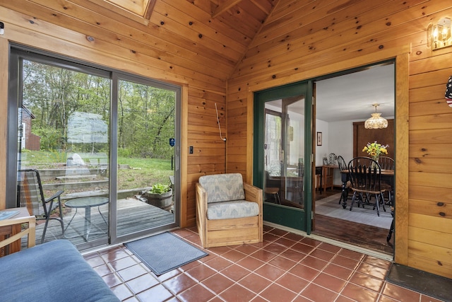 711 Biscay Rd, Bremen, ME 04551 - doorway with dark tile patterned flooring, wood walls, and vaulted ceiling