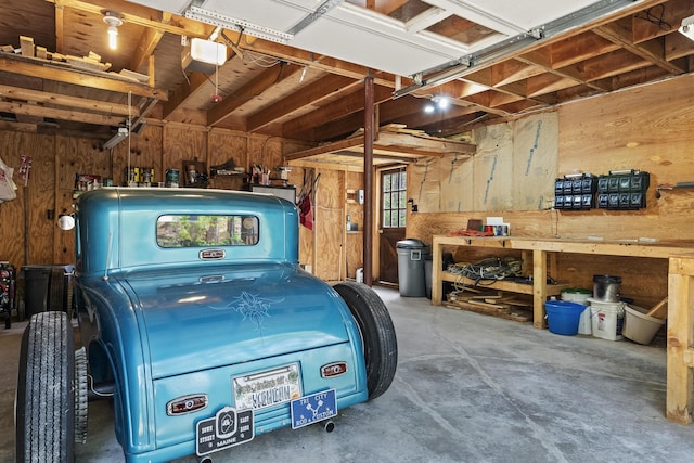 711 Biscay Rd, Bremen, ME 04551 - garage with wood walls, a workshop area, and a garage door opener