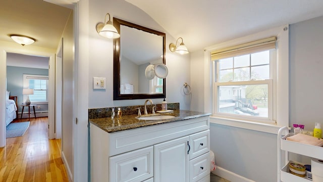 22 Vincent St, South Portland, ME 04106 - bathroom with wood finished floors, vanity, baseboard heating, baseboards, and vaulted ceiling