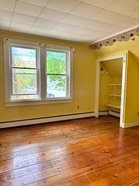 3 King St, Sanford, ME 04083 - empty room with hardwood / wood-style floors, a baseboard radiator, and vaulted ceiling