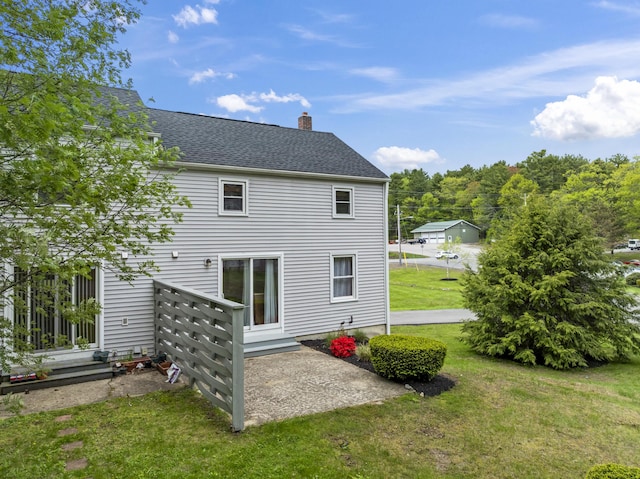 801 US Route 1 Unit C1, York, ME 03909 - back of house with a lawn, a chimney, roof with shingles, and a patio area