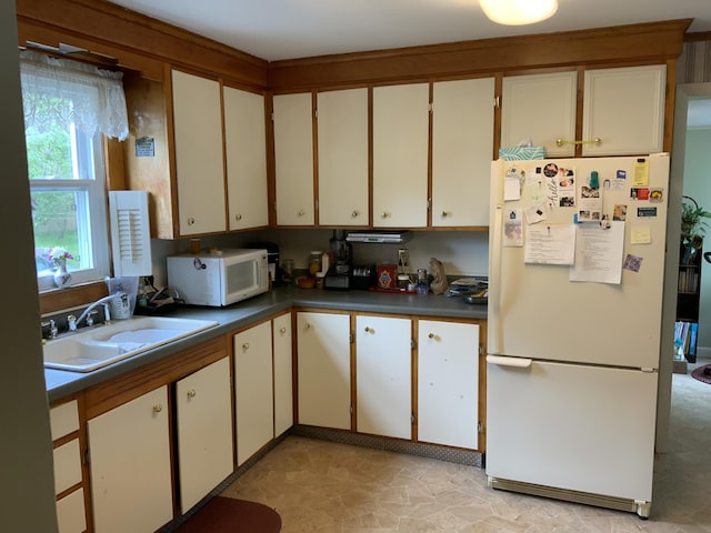 39 Oak St, Waterville, ME 04901 - kitchen with white appliances, a sink, light stone finish flooring, dark countertops, and white cabinetry