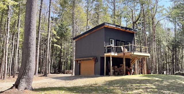 80 Bluejay Ln, Waltham, ME 04605 - view of front facade with a deck, a garage, and a wooded view