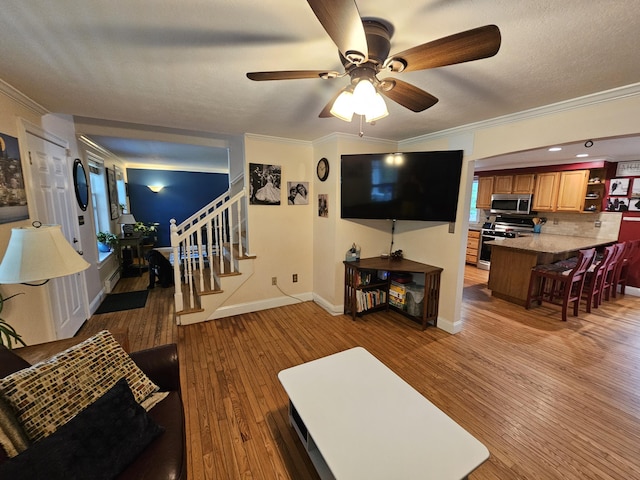 33 Oak Ridge Dr, Standish, ME 04084 - living room featuring stairs, ornamental molding, ceiling fan, light wood finished floors, and baseboards