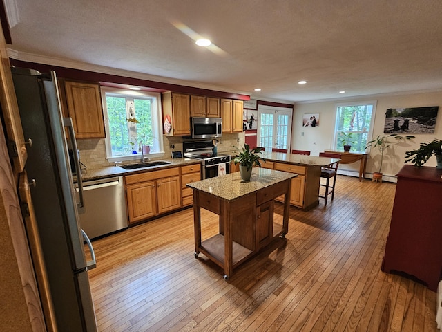33 Oak Ridge Dr, Standish, ME 04084 - kitchen with appliances with stainless steel finishes, a sink, a peninsula, a breakfast bar area, and tasteful backsplash