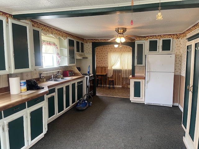 1 S Park St, Caribou, ME 04736 - kitchen with freestanding refrigerator, wallpapered walls, a sink, under cabinet range hood, and dark colored carpet