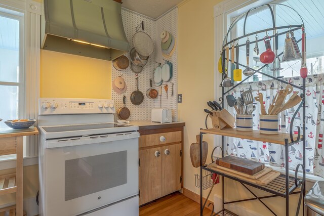 30 Hardys Hill Rd, Deer Isle, ME 04627 - kitchen with white electric range, range hood, and light wood-type flooring
