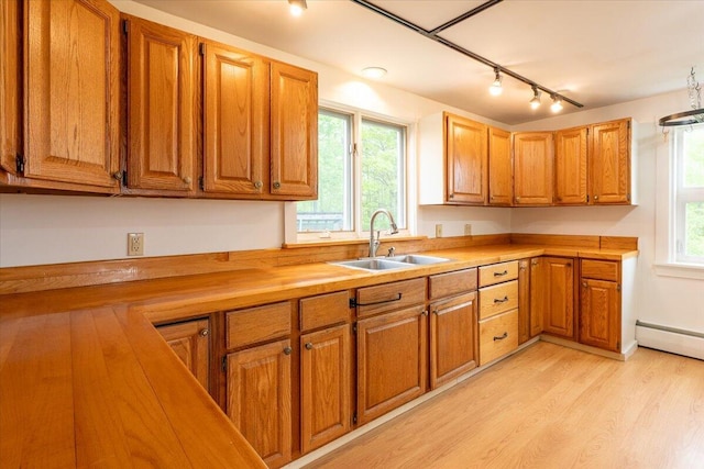 229 Choate Rd, Montville, ME 04941 - kitchen with a sink, rail lighting, brown cabinetry, light wood-type flooring, and a baseboard radiator