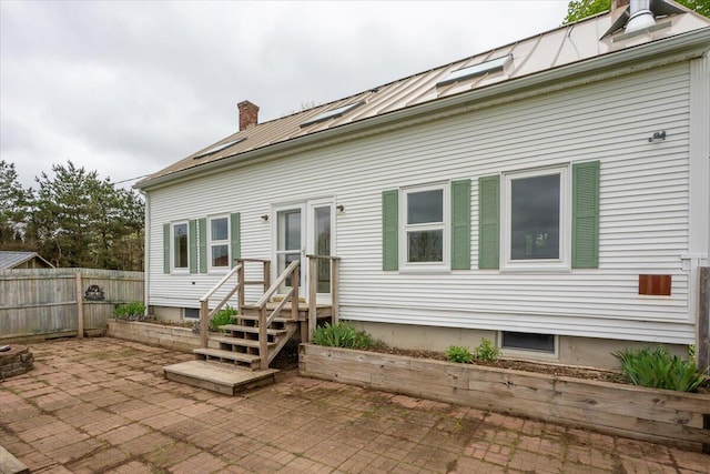 229 Choate Rd, Montville, ME 04941 - back of house featuring a chimney, a patio, metal roof, and a standing seam roof