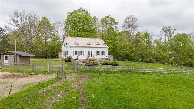 229 Choate Rd, Montville, ME 04941 - view of front of property featuring a chimney, metal roof, and an outdoor structure