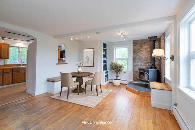 229 Choate Rd, Montville, ME 04941 - dining room with a baseboard heating unit, light wood-style floors, plenty of natural light, and a wood stove