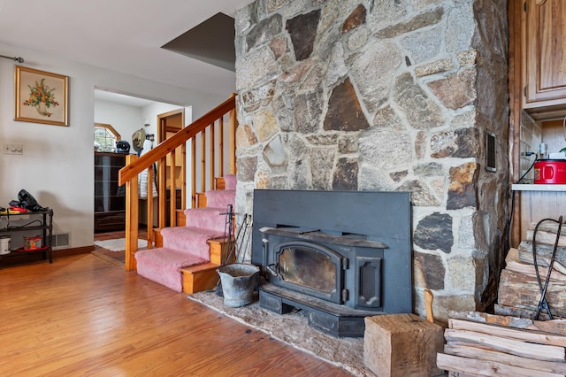 641 Bald Mountain Rd, Rangeley, ME 04970 - stairs featuring wood finished floors, baseboards, and a wood stove