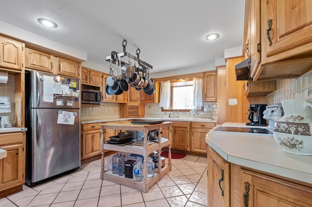 641 Bald Mountain Rd, Rangeley, ME 04970 - kitchen with freestanding refrigerator, black microwave, tasteful backsplash, light countertops, and range hood