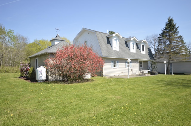 42 Blanchard St, Bangor, ME 04401 - rear view of property featuring a patio area, a gambrel roof, a lawn, and roof with shingles