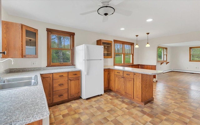 626 Main Rd, Eddington, ME 04428 - kitchen featuring freestanding refrigerator, a peninsula, a sink, brown cabinets, and light countertops